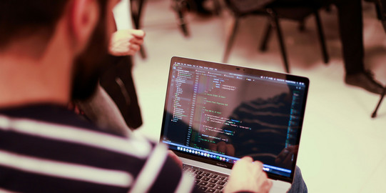 Mann arbeitet an Laptop