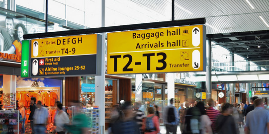 Menschen vor einem departure Schild.