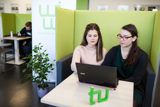 Zwei Studentinnen sitzen vor einem Laptop.