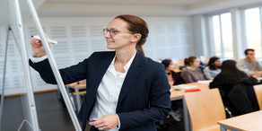 Studium_Menuebild Dozentin schreibt auf Flipchart.