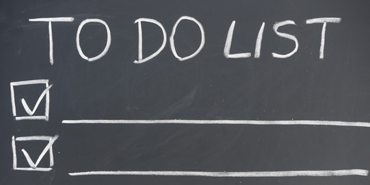 To-Do-Liste An einer Tafel steht die Überschrift „TO DO LIST”, darunter sind drei Zeilen mit Kästchen an der linken Seite und einem lange Unterstrich. In zwei Kästchen ist ein Haken gesetzt.