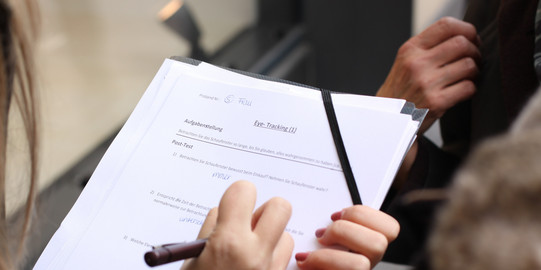 Fragebogen Eine Frau füllt einen Fragebogen zum Eye-tracking aus.