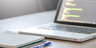 Arbeitsplatz mit Laptop und Notizen Foto eines Laptops und Notizbuches auf einem Schreibtisch.