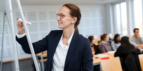Studium_Menuebild Dozentin schreibt auf Flipchart.